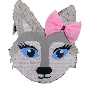 May include: Gray wolf piñata with blue eyes and a pink bow. The piñata is made of paper mache and is shaped like a wolf's head.