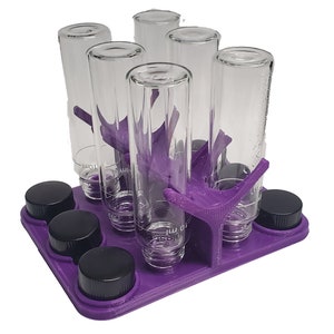 May include: Purple plastic test tube rack with six clear glass test tubes and black screw-on caps.