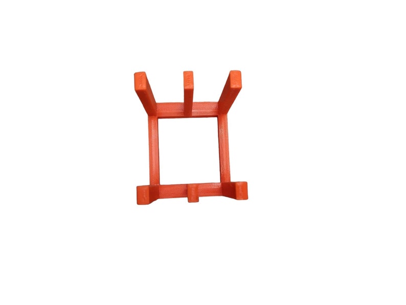 May include: A bright orange, square plant stand with a minimalist design. The stand has four vertical supports and a square base, perfect for displaying small potted plants. The stand is made of a solid material and is set against a white background.