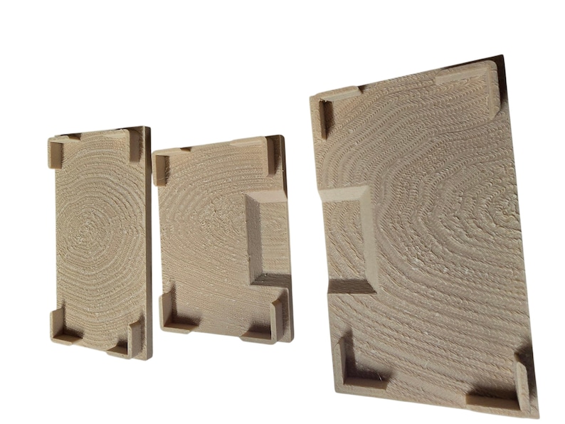 Pu&ograve; includere: Tre pannelli di legno di diverse dimensioni, ciascuno con un motivo circolare concentrico strutturato che ricorda la venatura del legno. I pannelli hanno elementi angolari e laterali rialzati, creando un effetto tridimensionale. Il legno &egrave; di colore marrone chiaro.