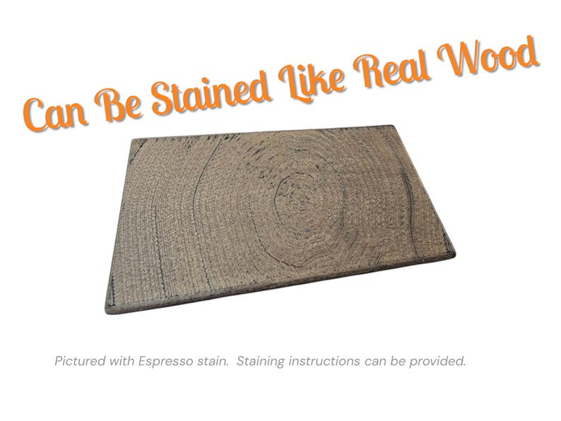 Pu&ograve; includere: Una tavola di legno rettangolare con un motivo a venature naturali, tinta con un colore espresso. Il testo "Can Be Stained Like Real Wood" &egrave; visualizzato in arancione. L'immagine mostra un primo piano della trama del legno.