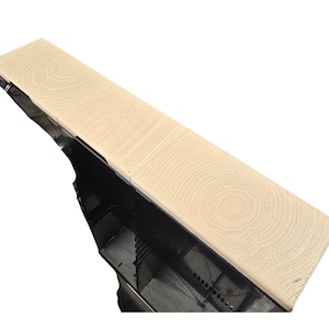 Pu&ograve; includere: Una mensola in legno di colore chiaro con un motivo a venature dettagliato. La mensola &egrave; rettangolare e sembra far parte di una struttura pi&ugrave; grande, con una rete metallica nera visibile al di sotto. La venatura del legno ha un motivo circolare.