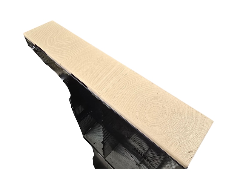 Pu&ograve; includere: Una mensola in legno di colore chiaro con un motivo a venature dettagliato. La mensola &egrave; rettangolare e sembra far parte di una struttura pi&ugrave; grande, con una rete metallica nera visibile al di sotto. La venatura del legno ha un motivo circolare.