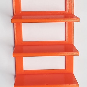 K&ouml;nnte beinhalten: Orange Wandregal mit vier Regalen und einem rechteckigen Design. Das Regal hat oben zwei L&ouml;cher zur Befestigung. Die Regale sind gleichm&auml;&szlig;ig angeordnet und haben eine schlichte, moderne &Auml;sthetik. Das Regal besteht aus einem durchg&auml;ngigen orangen Material.
