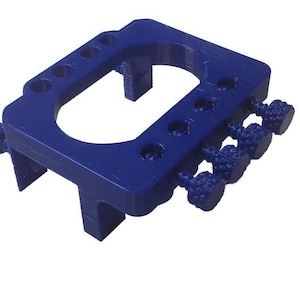 May include: A blue plastic 3D printed tool with multiple knobs and a circular opening. The tool is designed for holding and adjusting small objects.