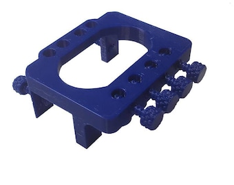 May include: A blue plastic 3D printed tool with multiple knobs and a circular opening. The tool is designed for holding and adjusting small objects.