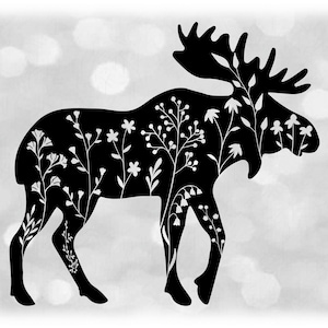 May include: Black silhouette of a moose with white floral designs inside the outline. The background is a blurred gray with white circles.
