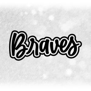 Op de afbeelding: Het woord "Braves" in een zwart, cursief lettertype met een witte omlijning, tegen een getextureerde, lichtgrijze achtergrond. Het ontwerp is eenvoudig en gedurfd, geschikt voor kleding of accessoires.