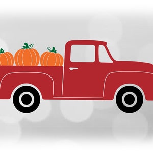 May include: A red pickup truck with a white background. The truck bed is filled with three orange pumpkins.