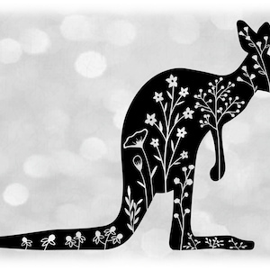 May include: Black silhouette of a kangaroo with white floral designs inside the silhouette. The background is a blurred out gray with white circles.