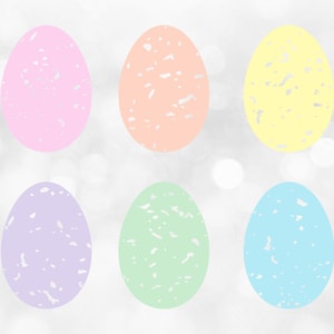 Puede incluir: Seis huevos de Pascua de color pastel con un patrón blanco moteado. Los huevos están dispuestos en dos filas de tres sobre un fondo blanco con un efecto bokeh.