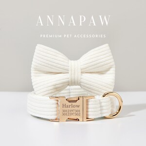K&ouml;nnte beinhalten: Ein wei&szlig;es Hundehalsband aus Baumwolle mit einer goldenen Schnalle und einer passenden wei&szlig;en Baumwoll-Fliege. Das Halsband tr&auml;gt den Namen "Harlow" und die Nummern "3012197301 3012197302" sind in die Schnalle graviert. Der Text "ANNAPAW PREMIUM PET ACCESSORIES" wird &uuml;ber dem Halsband und der Fliege angezeigt.