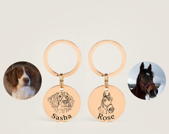 May include: Two gold keychains with personalized engraved round tags. One tag features a black and white line drawing of a dog with the name "Sasha" engraved below. The other tag features a black and white line drawing of a horse with the name "Rose" engraved below.