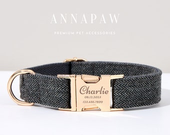 May include: A gray herringbone dog collar with gold-colored hardware. The collar features a gold buckle engraved with the name "Charlie", a date, and a phone number. The brand name "ANNAPAW" is displayed above the collar.