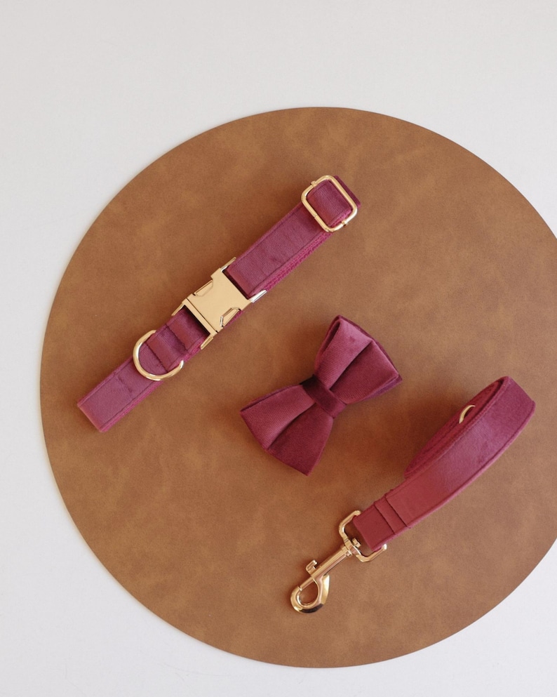 May include: Burgundy velvet dog collar and leash set with gold hardware and a matching burgundy velvet bow tie.