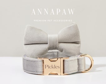 May include: A gray velvet dog collar with a gold buckle and a matching gray velvet bow tie. The collar has the name "Pickles" engraved on the buckle.
