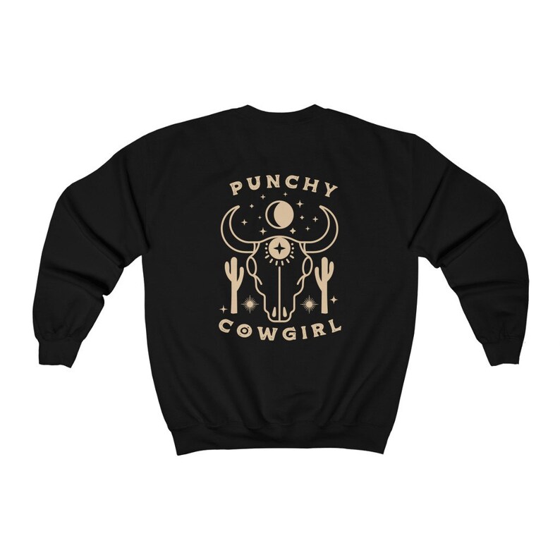 May include: Black sweatshirt with a tan graphic of a bull skull with a third eye, moon, stars, and cacti. The text "PUNCHY COWGIRL" is below the graphic.