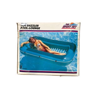 May include: Box for a blue Tan Dazzler Pool-Lounge inflatable pool float. The box features an image of a person relaxing on the float in a pool. The text "The Sport Set" and "Intex" are also visible.