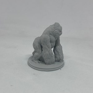 Könnte beinhalten: Eine graue, 3D-gedruckte Figur eines Gorillas, der auf einem runden Sockel sitzt.