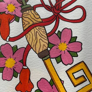 Könnte beinhalten: Illustration eines goldenen Schlüssels mit rotem Band und Quaste, umgeben von rosa Blüten mit gelben Zentren und grünen Blättern. Der Schlüssel hat einen dekorativen Griff mit Holzmaserung.