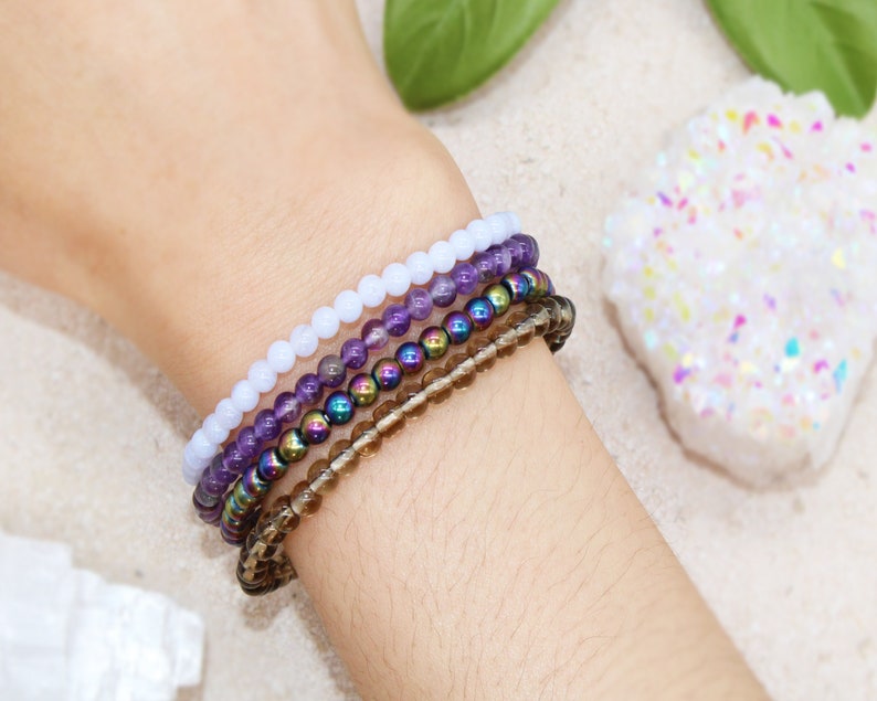 Anti Anxiety Crystal Bracelets 4mm round beads of Amethyst, Blue Lace Agate, Smoky Quartz, Rainbow Hematite on Women's Wrist. Dainty stackable crystal bracelet design with intention of relieving stress and worry.