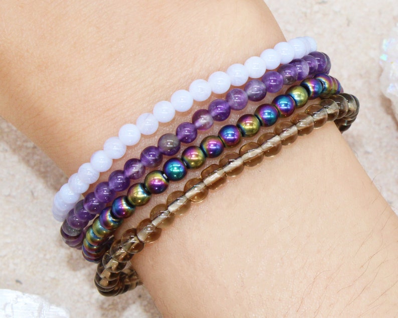 Anti Anxiety Crystal Bracelets 4mm round beads of Amethyst, Blue Lace Agate, Smoky Quartz, Rainbow Hematite on Women's Wrist. Dainty stackable crystal bracelet design with intention of relieving stress and worry.