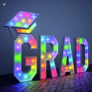 May include: A large, illuminated "GRAD" sign with a graduation cap. The letters and cap are white with colorful LED lights inside, creating a vibrant display. The lights cycle through various colors, including red, green, and blue.