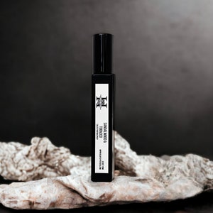 May include: A black roll-on bottle with a white label that reads "SMOKY & COCOA TOBACCO" and "NET WEIGHT 10 ML (0.33 FL OZ)".
