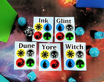 May include: Five white stickers with black text and symbols. The stickers are labeled "Ink", "Glint", "Dune", "Yore", and "Witch". Each sticker has four symbols: a sun, a skull, a flame, and a tree.