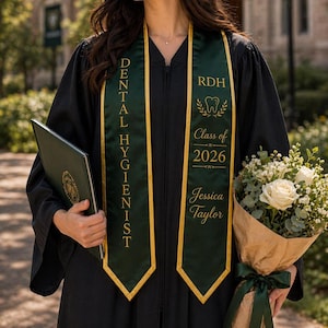 May include: A graduate in a black gown with a green and gold Dental Hygienist sash. The sash includes the text "RDH", a tooth graphic, "Class of 2026", and the name "Jessica Taylor". She holds a diploma and a bouquet of white roses.