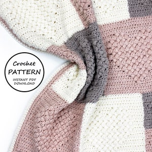 May include: A crochet blanket with squares in white, pink, and grey. The blanket is folded and the text "Crochet Pattern Instant PDF Download" is visible.