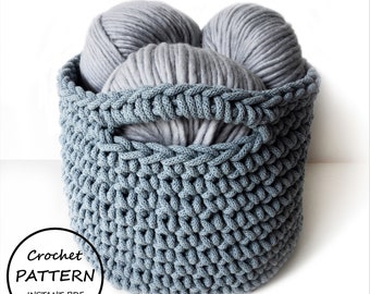 May include: A round, grey, hand-crocheted basket with integrated handles, filled with three large balls of matching grey yarn. A circular graphic in the bottom left corner contains the text: Crochet PATTERN INSTANT PDF DOWNLOAD.