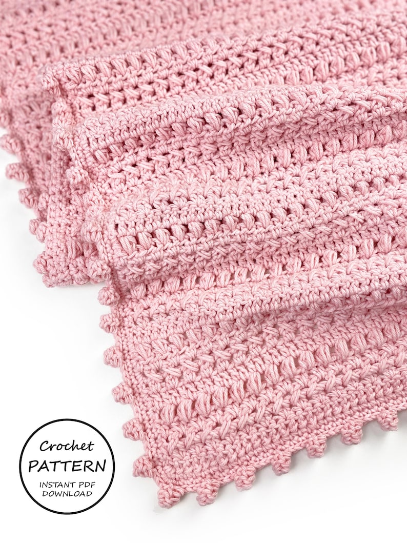 Pode incluir: Um close-up de um cobertor de croch&ecirc; rosa macio. O cobertor apresenta um padr&atilde;o de ponto texturizado e uma borda ondulada. As palavras "Crochet Pattern Instant PDF Download" est&atilde;o em um c&iacute;rculo no canto inferior esquerdo.