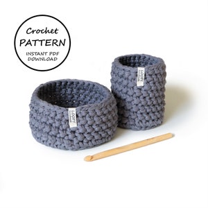 May include: Two gray crocheted baskets, one larger than the other, with a wooden crochet hook. The baskets have a label that says "LOOPY handmade". The text "Crochet PATTERN INSTANT PDF DOWNLOAD" is in a circle at the top of the image.