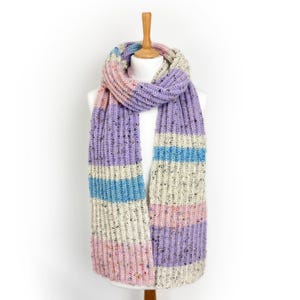 May include: A colourful, chunky knit scarf in pink, lilac, blue, and cream, displayed on a mannequin. The scarf has a ribbed design with flecks of colour. The scarf is approximately 178 cm long.