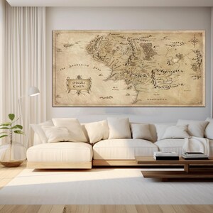 May include: A vintage-style map of Middle-earth, the fictional world from J.R.R. Tolkien's The Lord of the Rings, hangs on a white wall above a cream-colored couch in a living room.