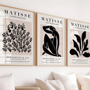 May include: Three black and white art prints with a beige background. The prints feature abstract shapes and the text "MATISSE PAPIERS DÉCOUPÉS BERGGRUEN & CIE".