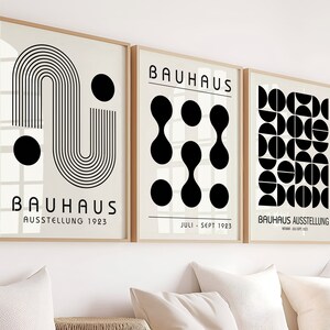 Peut inclure: Trois impressions d'art géométriques en noir et blanc avec le texte "Bauhaus Ausstellung" et des dates. Les impressions présentent des formes et des motifs abstraits.
