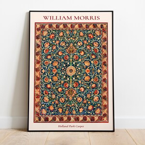May include: A framed print of a vintage William Morris Holland Park Carpet design. The carpet features a repeating pattern of stylized flowers and leaves in shades of red, orange, yellow, green, and blue on a dark blue background.