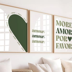 Peut inclure: Trois impressions d'art encadrées avec un fond blanc et du texte et des motifs vert olive. Les impressions présentent les mots "amor", "amour" et "More Amor Por Favor". La première impression a une forme de cœur et le mot "amor" autour du cœur.