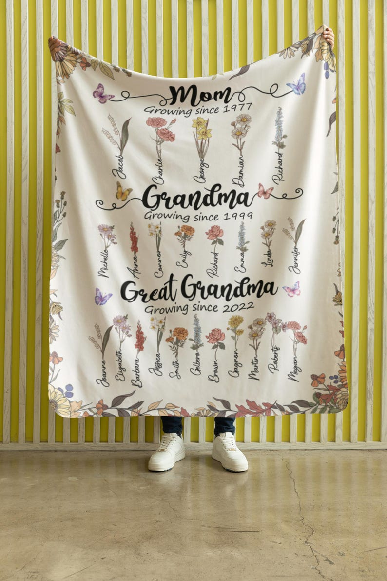 May include: A white floral blanket with the words "Mom Growing since 1977", "Grandma Growing since 1999", and "Great Grandma Growing since 2022" along with a list of names.