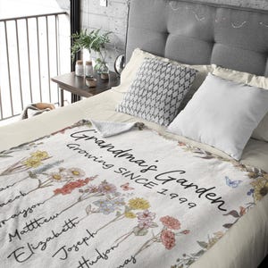 May include: White fleece blanket with a floral design and the text "Grandma's Garden Growing Since 1999".  The blanket features a variety of flowers and butterflies.  The names Jacob, Trayjon, Matthew, Elizabeth, Joseph, Hudson, and Thomas are written on the blanket.