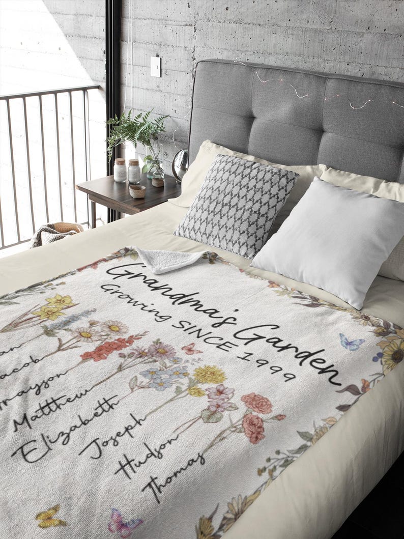 May include: White fleece blanket with a floral design and the text "Grandma's Garden Growing Since 1999".  The blanket features a variety of flowers and butterflies.  The names Jacob, Trayjon, Matthew, Elizabeth, Joseph, Hudson, and Thomas are written on the blanket.