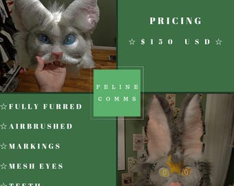 May include: A fully furred feline mask with airbrushed details, markings, mesh eyes, teeth, and whiskers. The mask has large ears and is primarily gray with blue eyes and pink accents. The text "FELINE COMMS" is visible.