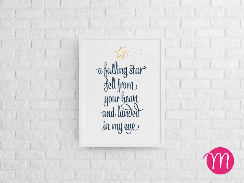 以下が含まれることがあります： 金色の星と紺色の文字で「a falling star fell from your heart and landed in my eye」と書かれた白い額装されたプリントです。