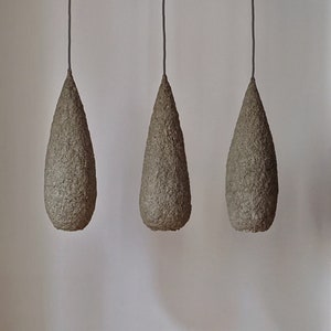 Set di tre lampade a sospensione realizzate in pasta di carta. Colore beige. Materiali naturali. vegano. Modelli 11, 12, 13 set.