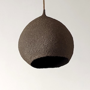 Brązowa lampa z obłym abażurem w nieregularnym kształcie. Z każdej strony lampa ma odmienny kształt. Wewnątr złota. Vege. Model 20BRG.