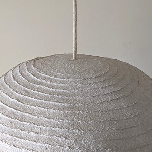 Oval hanging large lamp made of papier mache. Is formed from thinner and thicker layers. Special "armored" packaging. Model 21.