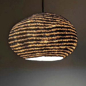 Owalna lampa wisząca z papier mache. Abażur uformowany z cieńszych i grubszych warstw. Naturalne komponenty, Vegan. Model 21.