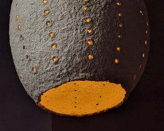 Langwerpige ovale vorm met gaten in de schelp Papier-maché beige hanglamp. Verticale vorm. Wabi sabi-lamp. Natuurlijke ingrediënten. Model 41